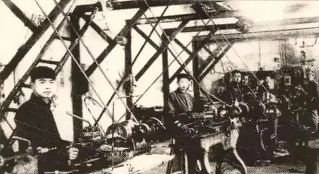 The workers in the picture are operating a belt lathe